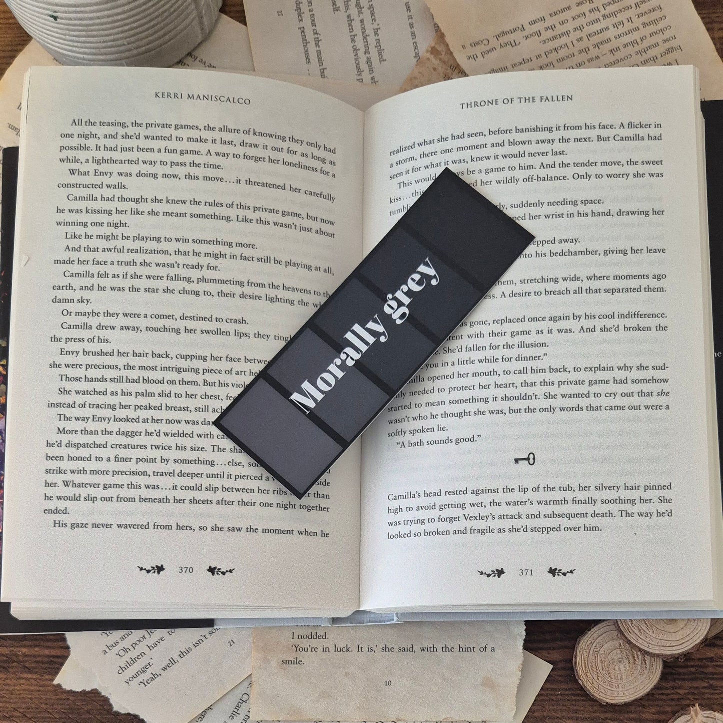 The morally grey bookmark is pictured ontop an open book.