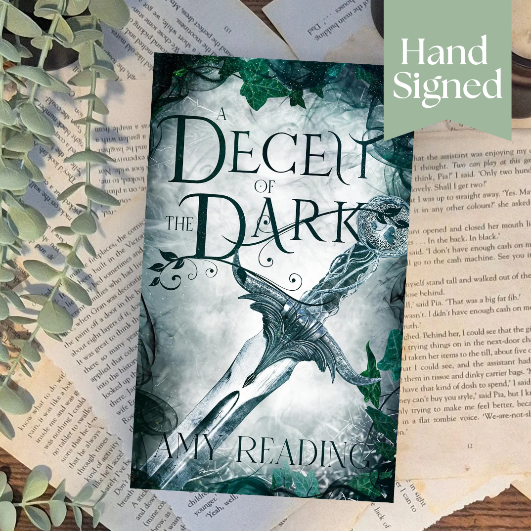 Book titled 'A Decent of the Dark' with decorative elements on a textured surface.